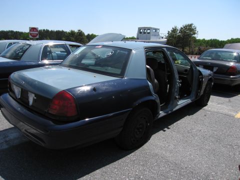 1991 Ford LTD Crown Victoria - Two Ford Crown Victorias are parked outside, one with its doors open and interior exposed.