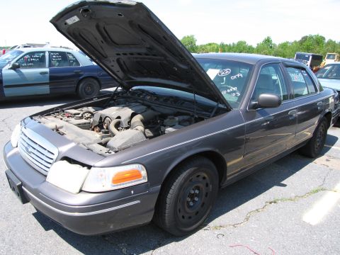 1991 Ford LTD Crown Victoria - A dark gray sedan with its hood open, revealing the engine compartment, parked outdoors.