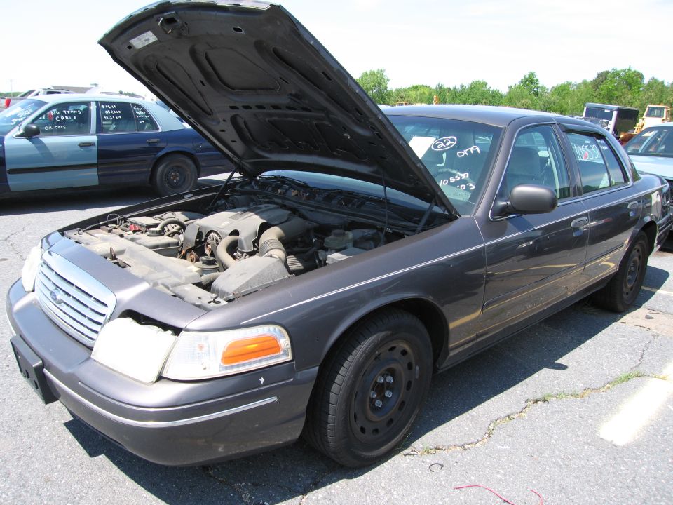 Dark gray sedan with hood open, showing engine. Visible text on windshield: '22 J 079 10603 03'