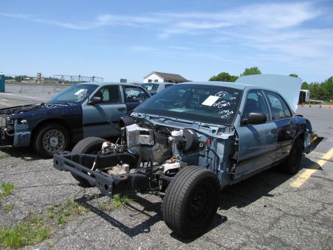 1991 Ford LTD Crown Victoria - Two Ford Crown Victorias are parked outside, both in a state of disrepair.