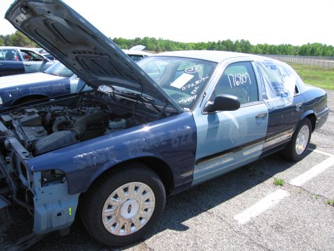 1991 Ford LTD Crown Victoria - A blue Ford Crown Victoria sits in a lot with its hood open, revealing the engine bay.