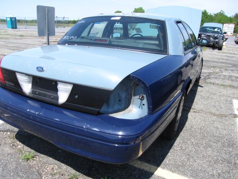1991 Ford LTD Crown Victoria - Two-tone Ford Crown Victoria shows damage to rear passenger side; another vehicle is visible in the background.