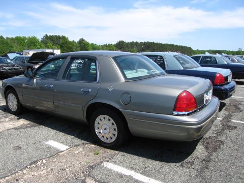 1991 Ford LTD Crown Victoria - Several Ford Crown Victorias are parked in a lot under a blue sky.
