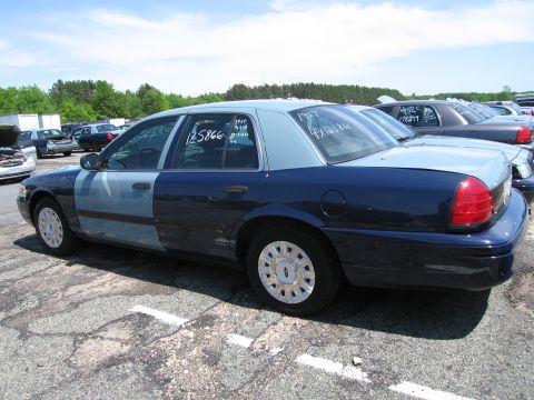 1991 Ford LTD Crown Victoria - Two-tone Ford Crown Victoria parked in a lot with other vehicles. White markings on windows indicate year and lot number.