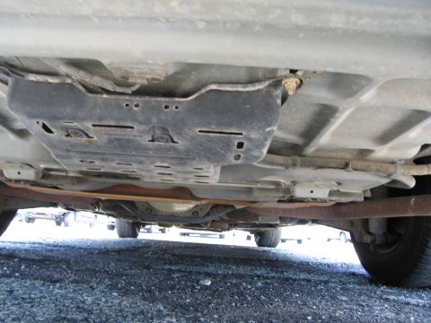 1991 Ford LTD Crown Victoria - The undercarriage of a vehicle is visible, showing a skid plate and exhaust system.