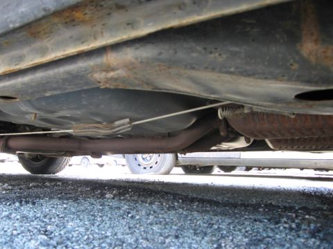 1991 Ford LTD Crown Victoria - Underside view of a car, revealing the exhaust system, fuel tank, and suspension components.