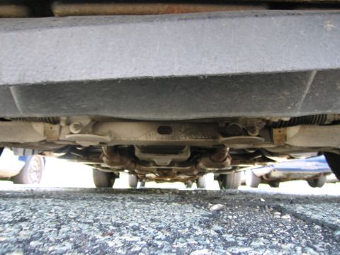 1991 Ford LTD Crown Victoria - A low-angle view of a vehicle's undercarriage, revealing mechanical parts and exhaust systems.