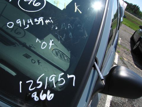 1991 Ford LTD Crown Victoria - Writing on the windshield includes mileage and other notations, with a side mirror and another vehicle in the background.