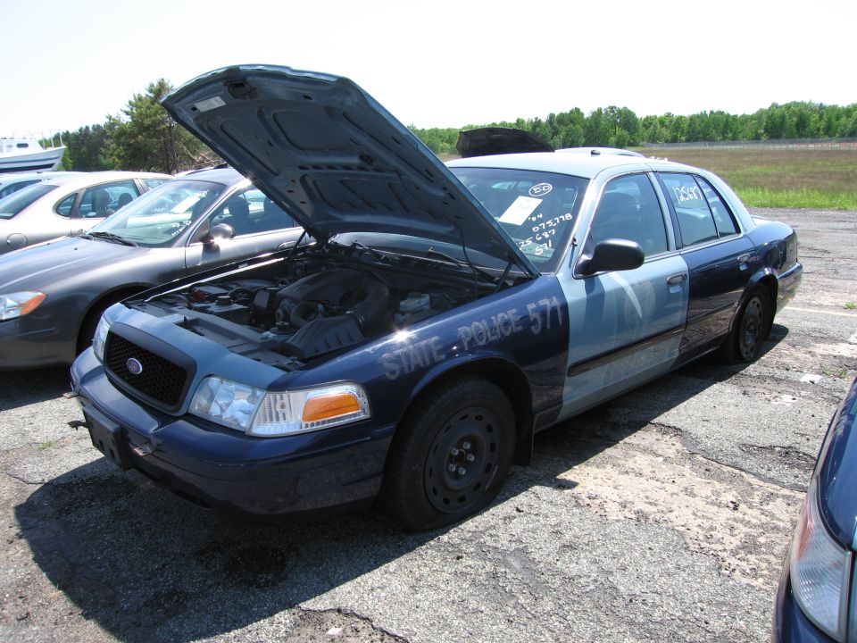 Blue and light blue Ford Crown Victoria Police Interceptor with hood open, "STATE POLICE 571" text on door