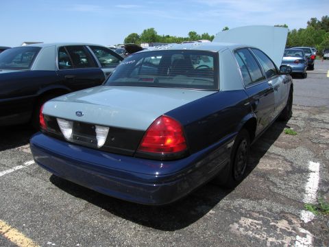 1991 Ford LTD Crown Victoria - This two-tone blue and gray Ford Crown Victoria, likely a 1998 model, is parked in a lot with its hood up.