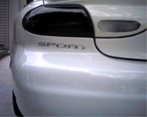 1997 Ford Taurus - Close-up of the rear of a silver car, showing the taillight and 'SPORT' emblem.