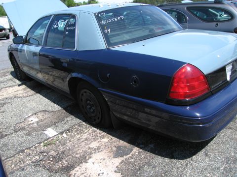 1991 Ford LTD Crown Victoria - Side view of a two-tone 1991 Ford Crown Victoria showing its body style and a flat tire.