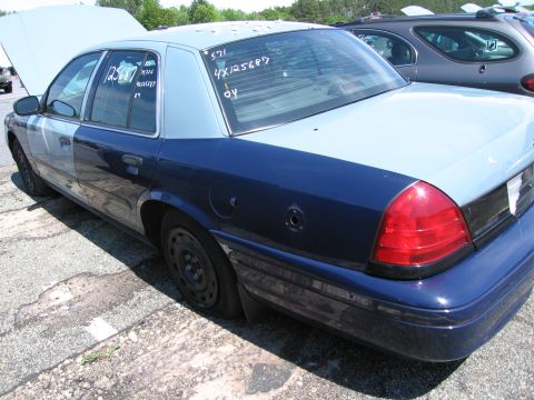 1991 Ford LTD Crown Victoria - This Ford Crown Victoria has a two-tone paint job and visible markings on the windows. Another vehicle is parked behind it.
