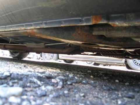 1991 Ford LTD Crown Victoria - Underside of a car with visible rust on the frame and exhaust system.