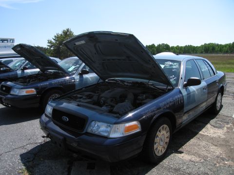 1991 Ford LTD Crown Victoria - Several Ford Crown Victoria police cars are lined up with their hoods open, showing their engines.
