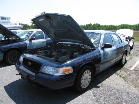 1991 Ford LTD Crown Victoria - A Ford Crown Victoria police car, marked "STATE POLICE 1793", sits with its hood open next to another police vehicle.
