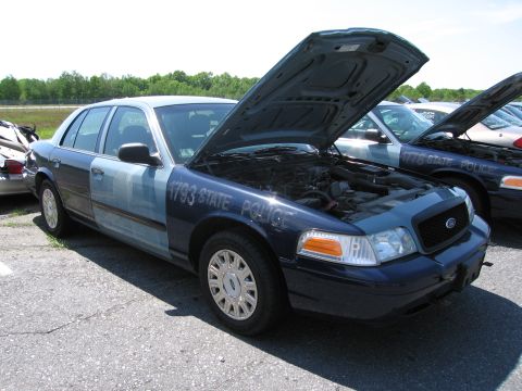 1991 Ford LTD Crown Victoria - Two Ford Crown Victoria police cars are parked with hoods open, one marked "1793 STATE POLICE".