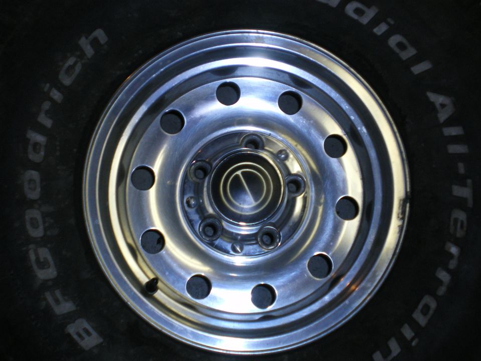 Close-up of a BFGoodrich All-Terrain tire with a chrome wheel showing lug nuts
