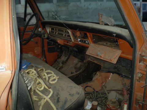 1969 Ford F-250 - The interior of this old truck is covered in dust and shows signs of wear and tear.