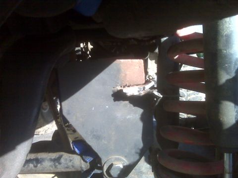 1969 Ford F-250 - Close-up of a vehicle's undercarriage, showing suspension parts and metalwork.