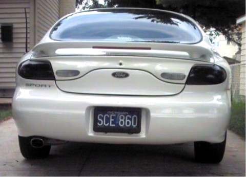 1997 Ford Taurus - The rear of a white 1997 Ford Taurus is shown, tinted taillights and a 'SPORT' badge.