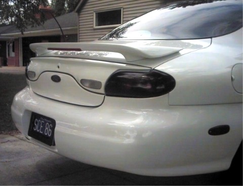 1997 Ford Taurus - Rear view of a white 1997 Ford Taurus, a spoiler and tinted taillights.