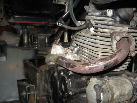 2010 Kawasaki BAYOU 220 - Close-up view of a motorcycle engine, showing mechanical components and a watermarked website address.