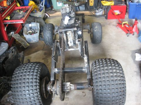 2010 Kawasaki BAYOU 220 - ATV frame with engine and wheels, showing chain drive and rear axle assembly.