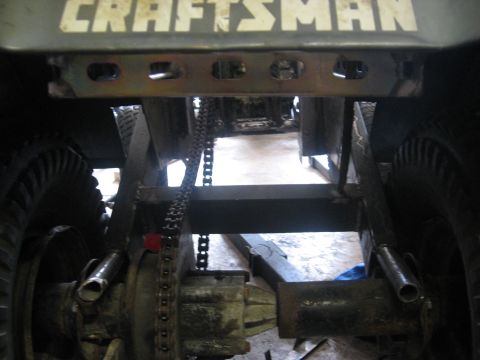 2010 Kawasaki BAYOU 220 - The rear axle and drive chain of a vehicle are visible, with 'CRAFTSMAN' text overhead.