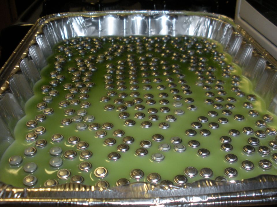 Pan of bullets being cast in green liquid