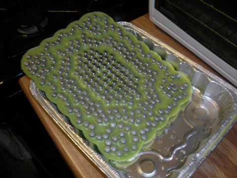 1996 Ford Bronco - A green object with numerous metal studs is placed inside a foil pan.