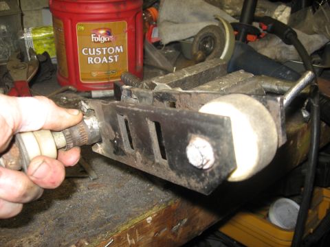 2010 Kawasaki BAYOU 220 - Part held in vise with a roller wheel and splined shaft.