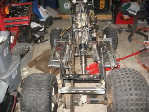 2010 Kawasaki BAYOU 220 - ATV frame and engine components are exposed, suggesting it is undergoing maintenance or repair.