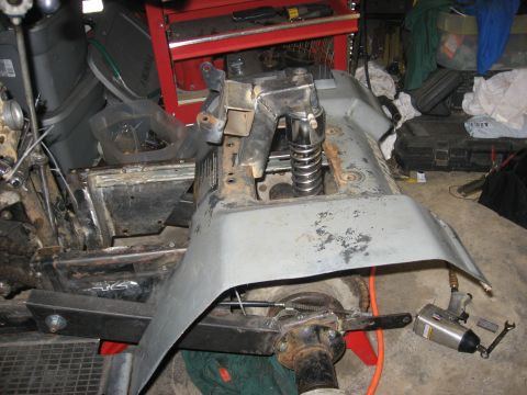 2010 Kawasaki BAYOU 220 - ATV frame being worked on, with tools and parts scattered around the workspace.