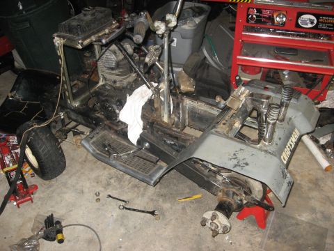 2010 Kawasaki BAYOU 220 - Disassembled lawn tractor frame and engine, with 'CRAFTSMAN' visible on a part.