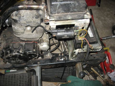 2010 Kawasaki BAYOU 220 - Close-up view of a motorcycle's engine and frame components, showing wiring and mechanical parts.