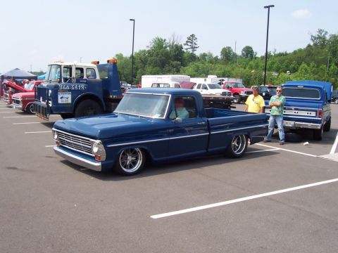 2007 Ford Mustang - A lowered blue 1967 Ford pickup truck is parked at an outdoor event with other vehicles.