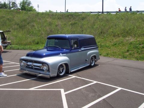 2007 Ford Mustang - A custom 1956 Ford panel van with a lowered stance and chrome wheels is displayed at an outdoor event.