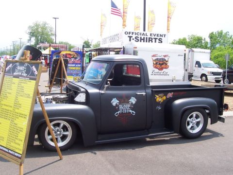 2007 Ford Mustang - A custom black pickup truck is parked at an outdoor event with a parts list displayed nearby.