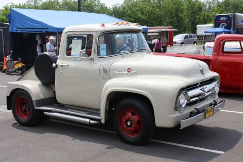 2007 Ford Mustang - Cream-colored pickup truck parked next to a red truck at an outdoor event.