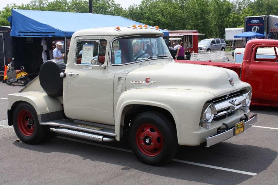 Cream-colored pickup truck with red wheels and a spare tire mounted on the side