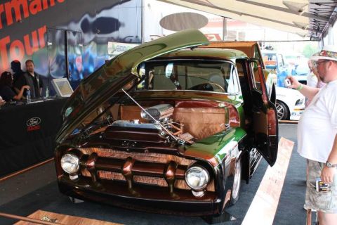 2007 Ford Mustang - A customized Ford F-100 pickup truck is displayed with its hood and door open at an event.