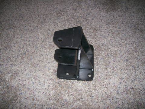 1993 Ford Bronco - A fabricated metal bracket with welded seams and pre-drilled holes is shown on a carpeted surface.