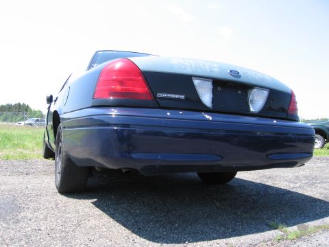 1991 Ford LTD Crown Victoria - Rear view of a 1991 Ford Crown Victoria LTD Police Interceptor, showing its taillights and 'Police Interceptor' badge.