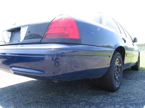 1991 Ford LTD Crown Victoria - The rear of a blue sedan is shown from a low angle, highlighting the taillight and bumper.