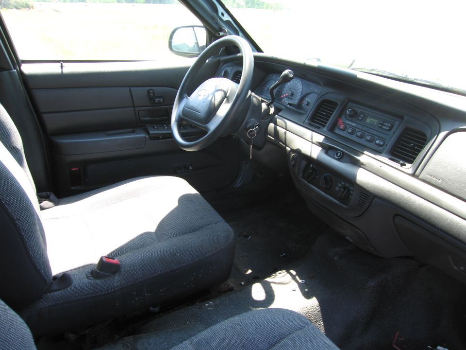 Interior shot of a Ford Crown Victoria, showing the dashboard, steering wheel, and front seats