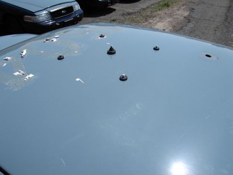 1991 Ford LTD Crown Victoria - The hood of a light blue 1991 Ford Crown Victoria LTD shows multiple studs and holes.