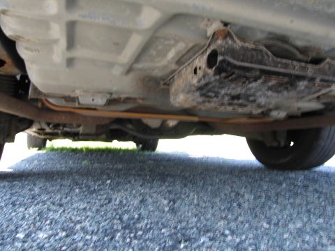 1991 Ford LTD Crown Victoria - Underside view of a car, showing the exhaust system and rear tire.