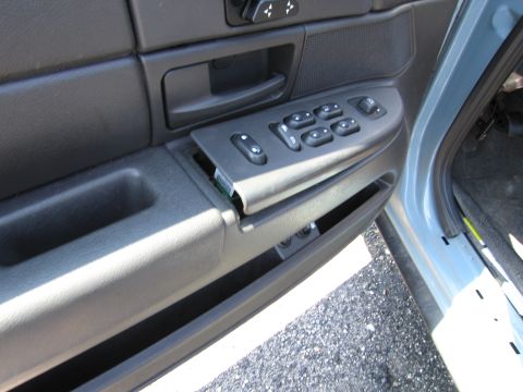 1991 Ford LTD Crown Victoria - Interior view of a car door panel showing window controls and a loose trim piece.