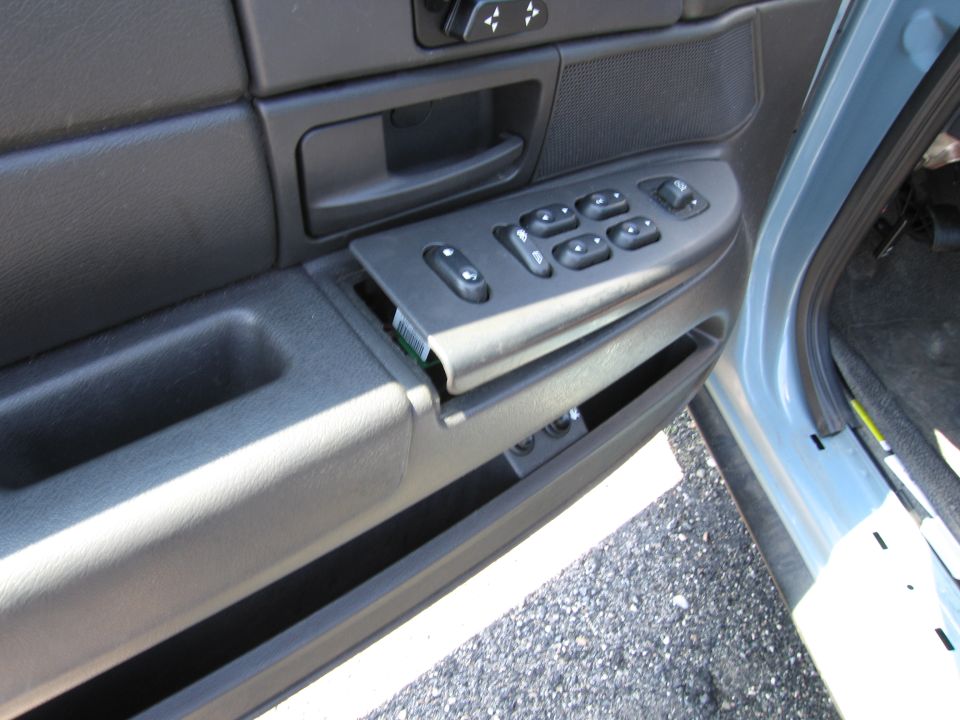 Car door panel with window and lock switches, one panel is loose